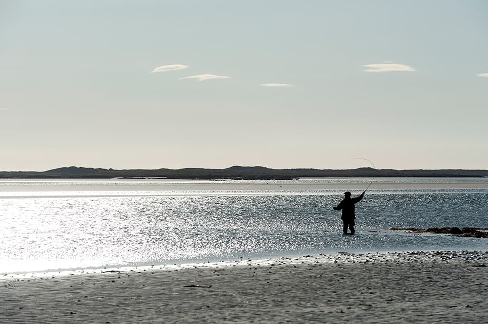 An angler casting a fly over a North Uist sea pool
